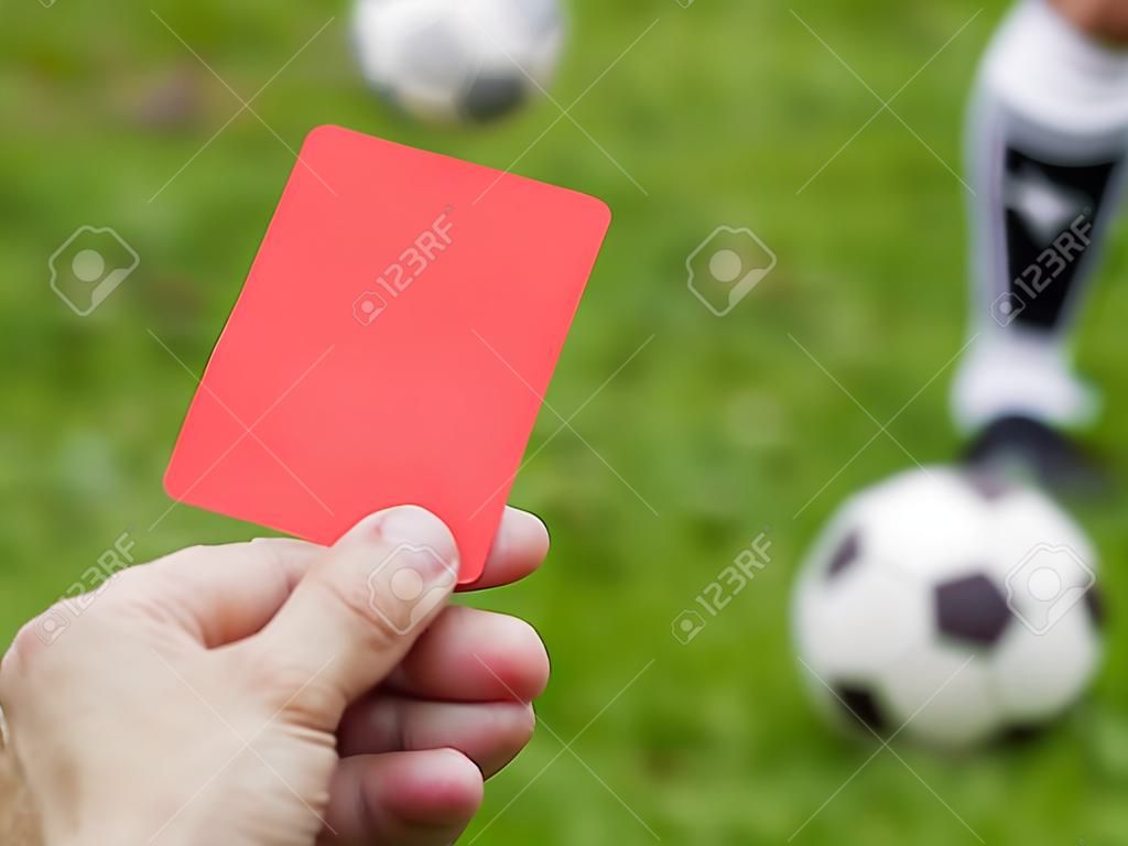 Hand omhoog rode kaart tegen voetbalveld