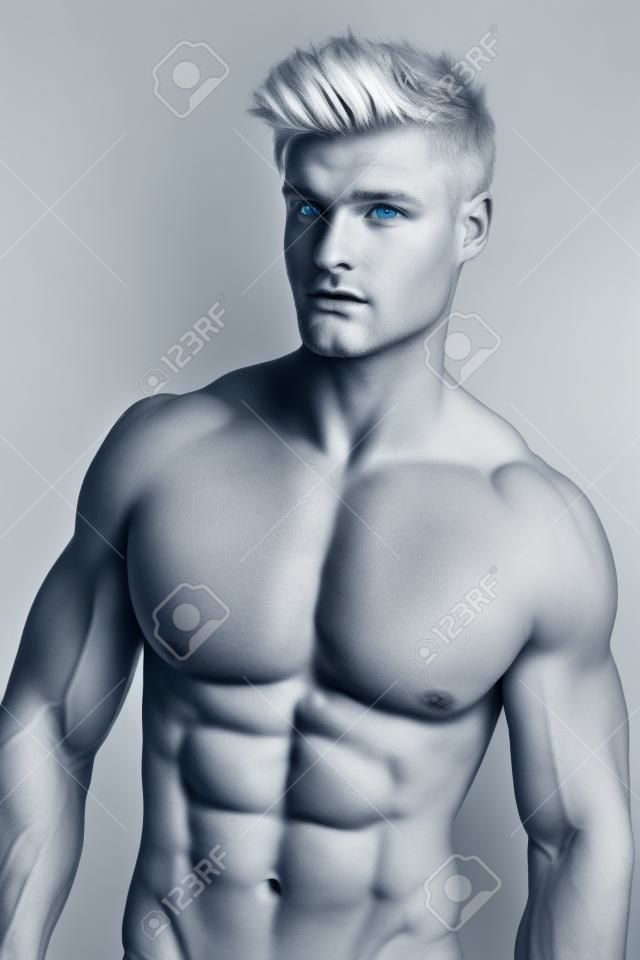 Hombre rubio, atlético, con ojos azules y un cuerpo musculoso superior