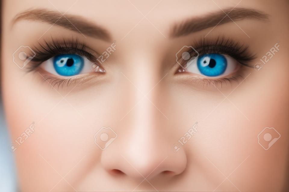 파란 눈과 코를 가진 젊은 금발 여자의 근접 촬영