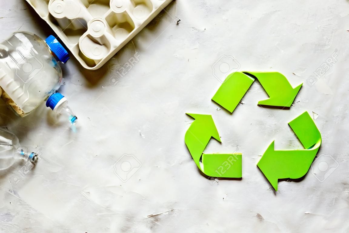 resíduos e símbolo de reciclagem no cuidado ecológico na vista superior de pedra