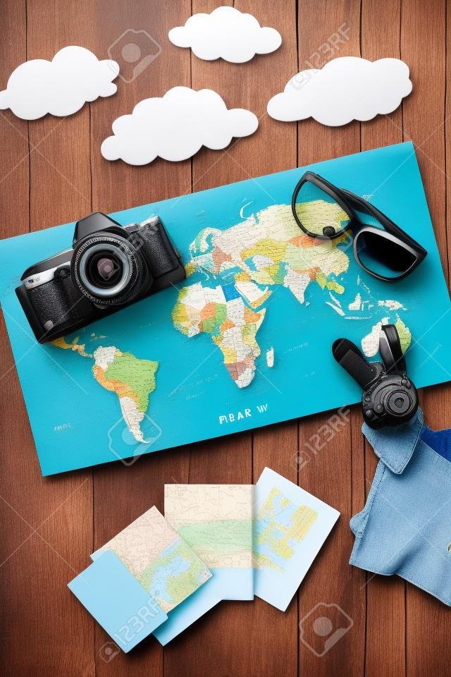 tourist outfit and camera with map for trip with kids on dark wooden background top view mockup