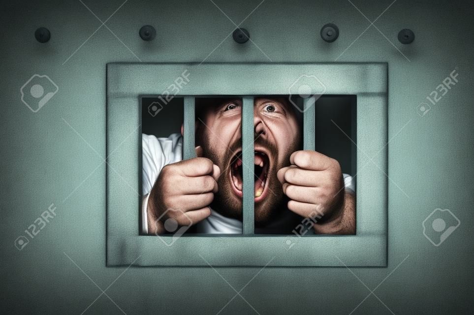 Hombre en la cárcel va loco, agarrar los barrotes de su celda de la cárcel, buscando rabit y gritando incontrolable