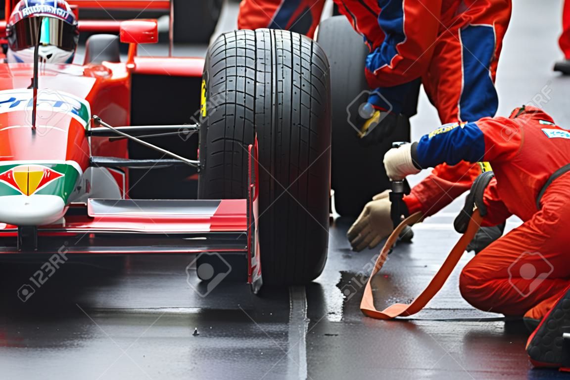 Professional racing team at work during a pitstop of a race car in the pitslane during a car race.