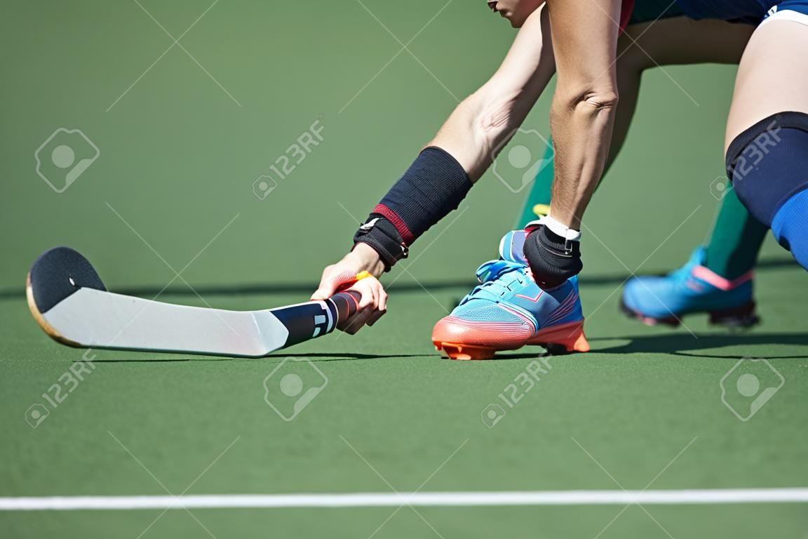 Field Hockey player, forcefully passing the ball to a tream mate