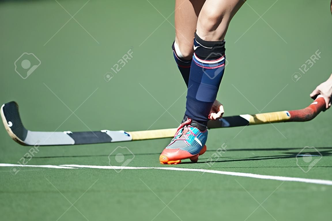Field Hockey player, forcefully passing the ball to a tream mate