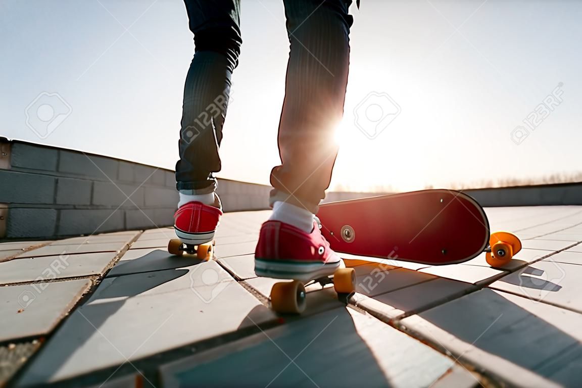 конькобежец верхом на скейтборд. Вид человека верхом на своем коньке носить повседневную одежду