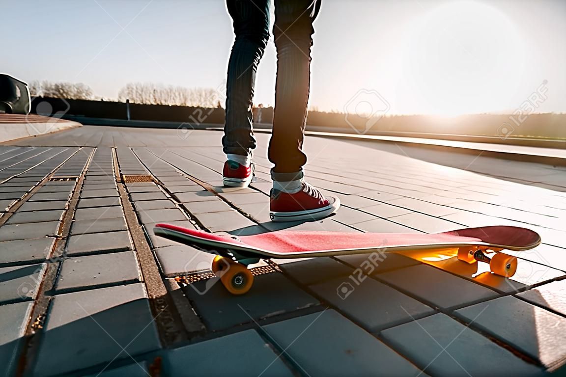 skater montando um skate. vista de uma pessoa andando em seu skate vestindo roupas casuais