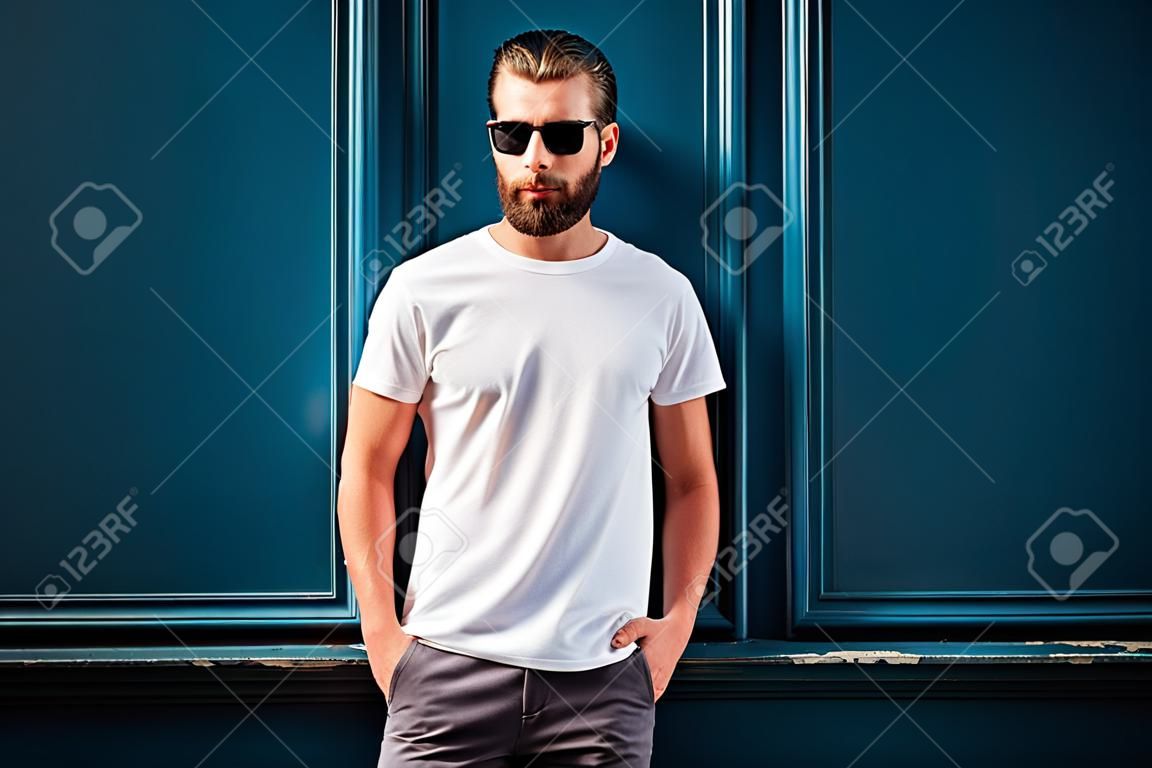 hipster beau modèle masculin avec barbe portant t-shirt blanc blanc avec espace pour votre logo ou un design dans un style décontracté décontracté