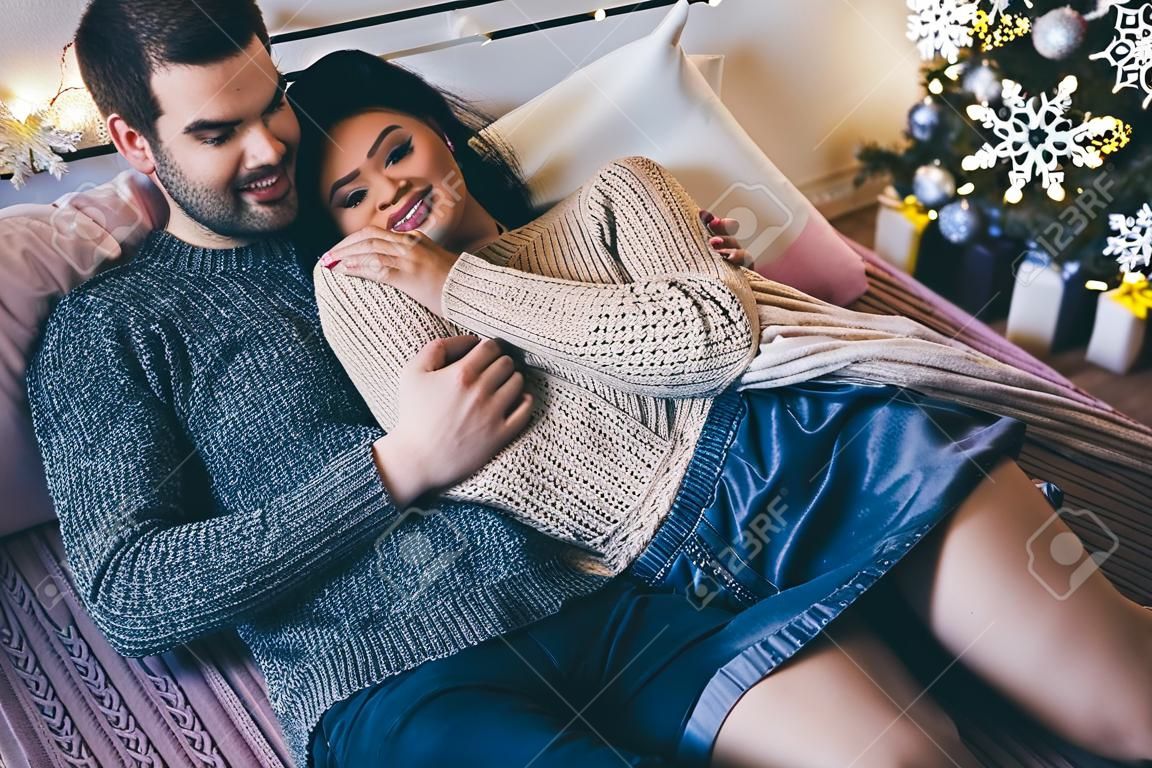 Couple romantique passionné, passer du temps avant le nouvel an près de bel arbre de Noël à la maison