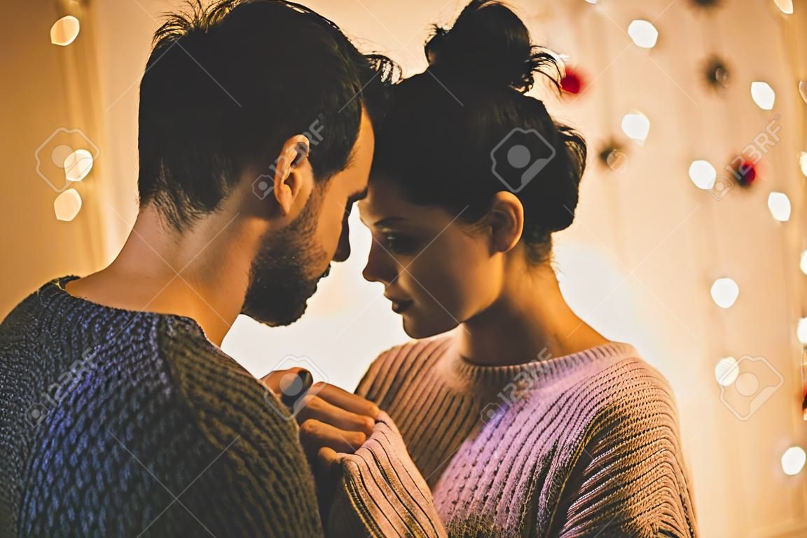 充满激情的浪漫情侣，穿着毛衣正在新年前在家度过时光