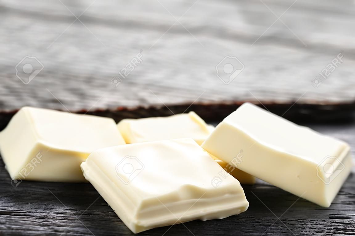 Trozos de chocolate blanco sobre mesa de madera gris
