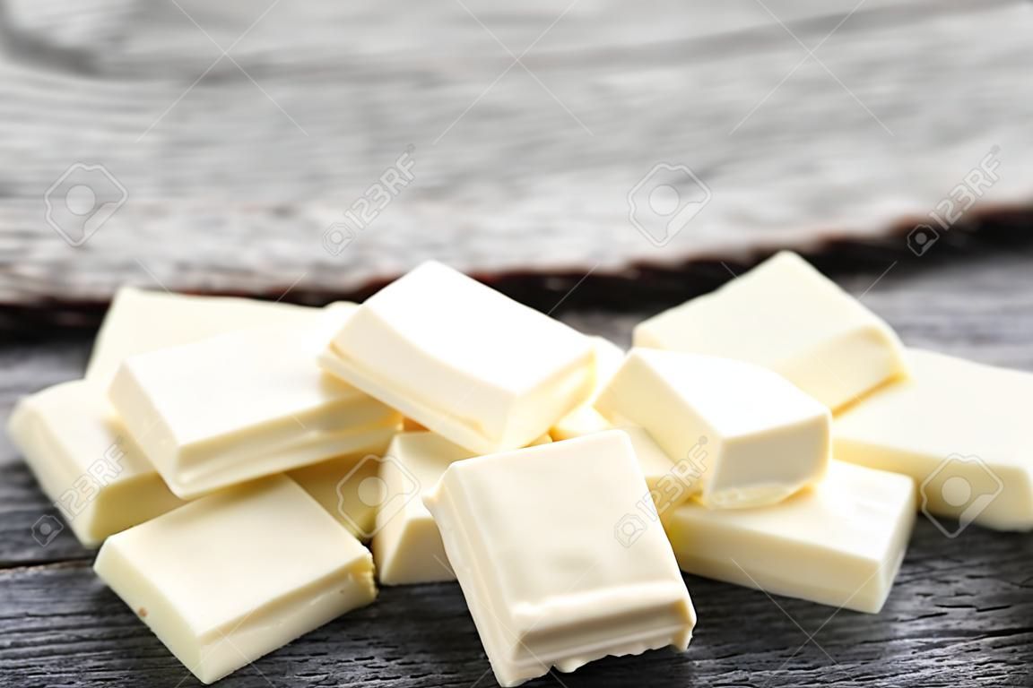 Trozos de chocolate blanco sobre mesa de madera gris