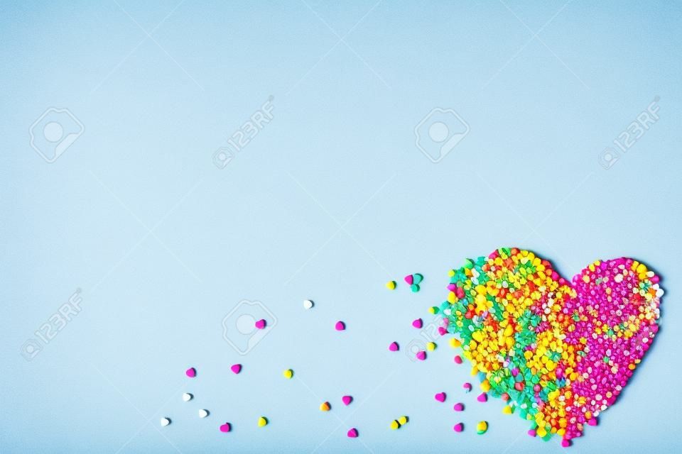 Colorful heart shaped sprinkles on white background