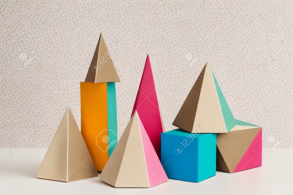 Colorful paper geometric figures on beige background