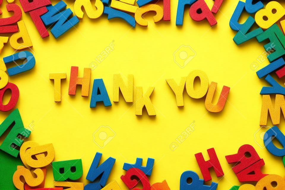 Word Thank You by wooden letters on yellow background