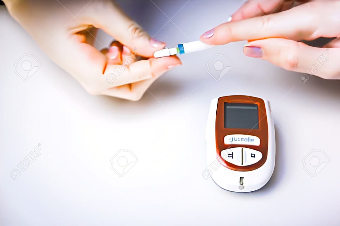 Close-up Of Woman Hands Testing High Blood Sugar With Glucometer, Blood glucose meter, The blood sugar value is measured on a finger, Syringe pen with insulin and glucometer