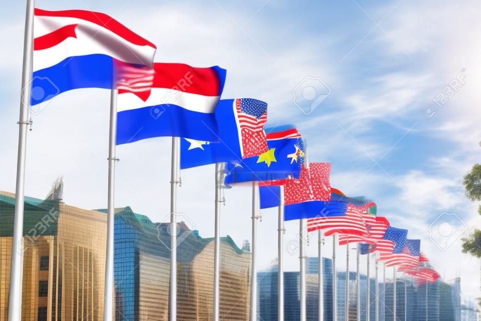 Sventolando bandiere nazionali di diversi paesi su pennoni sullo sfondo di edifici urbani