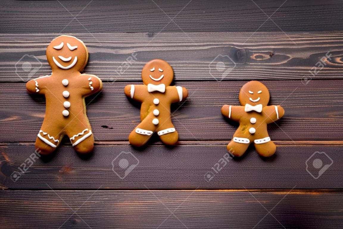 Gingerbread man cookies on wooden background top view.