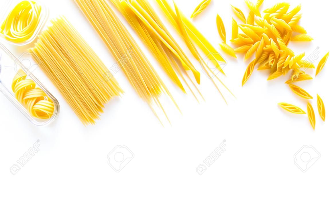 Set of pasta. Raw spaghetti, fusilli, penne, fettuccine on white background top view.