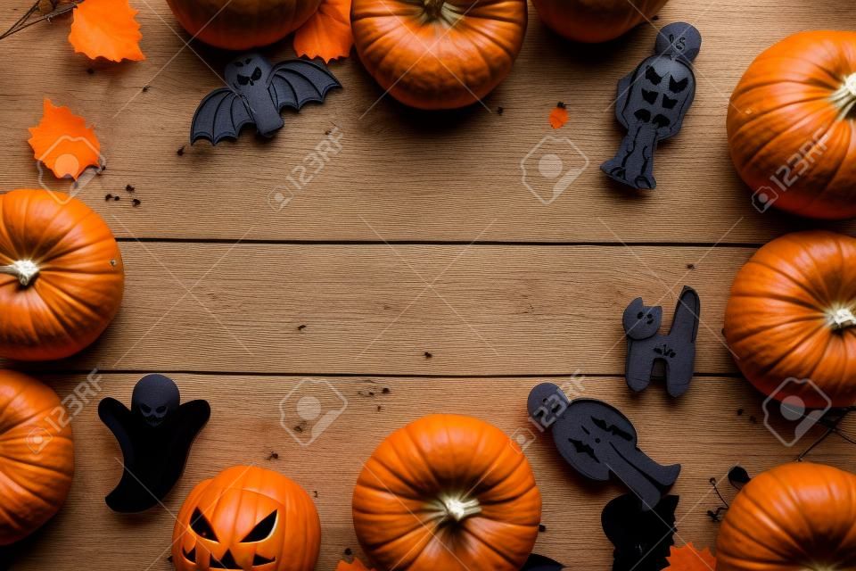 Preparing to Halloween. Pumpkins and cute figures of halloween evils. Bats, skeleton, ghosts. blue wooden background top view copy space