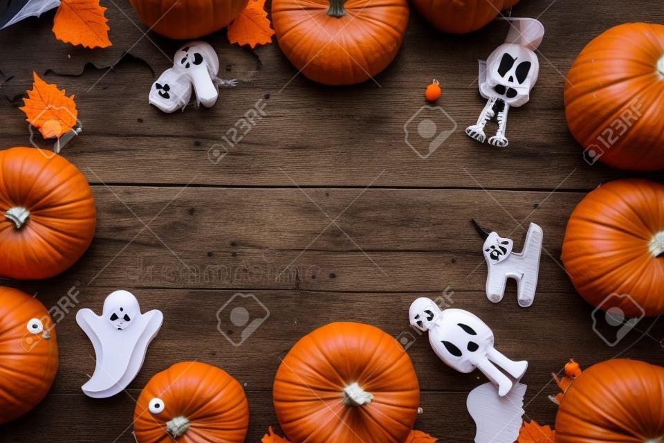 Preparing to Halloween. Pumpkins and cute figures of halloween evils. Bats, skeleton, ghosts. blue wooden background top view copy space