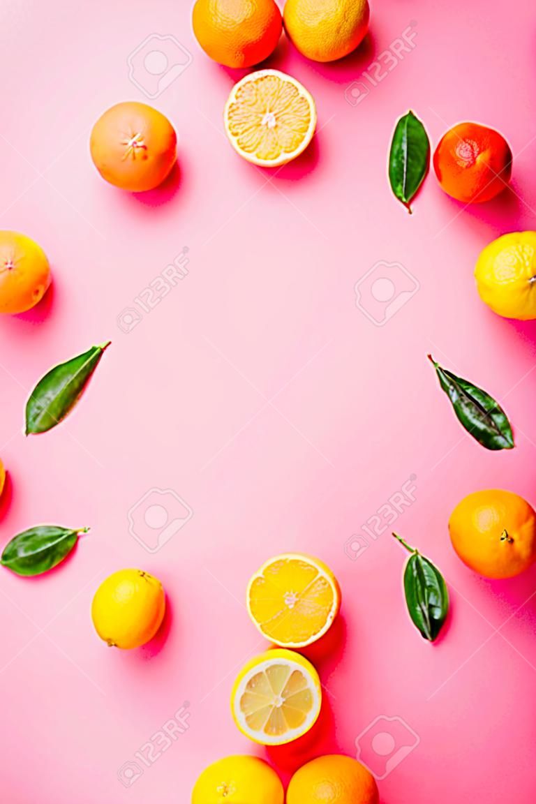Citrus fruits - lemons, grapefruits - on pink background mockup, frame top-down copy space