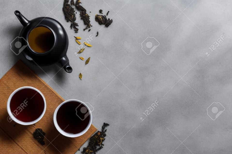 Tea drinking with white teapot and black tea in two cups