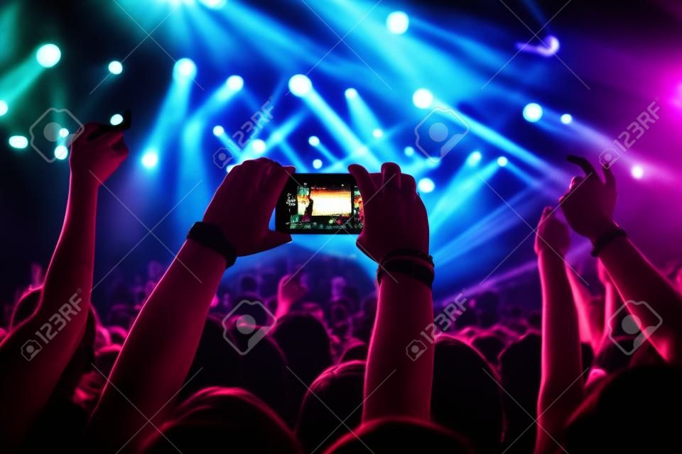 Fan che scatta foto con il cellulare a un concerto