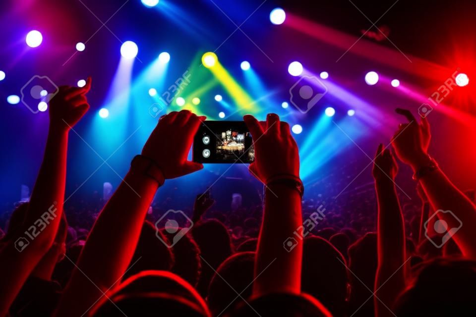 Fan taking photo with cell phone at a concert