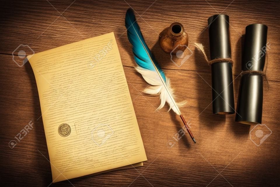 Plume, plume avec une lettre et un rouleau sur une table en bois. Notion de cru