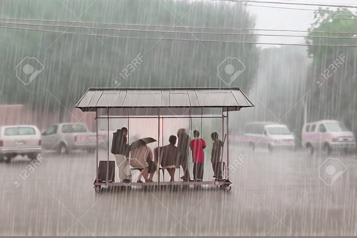 Het publiek verbergt zich voor zware regen bij een stop in de stad.