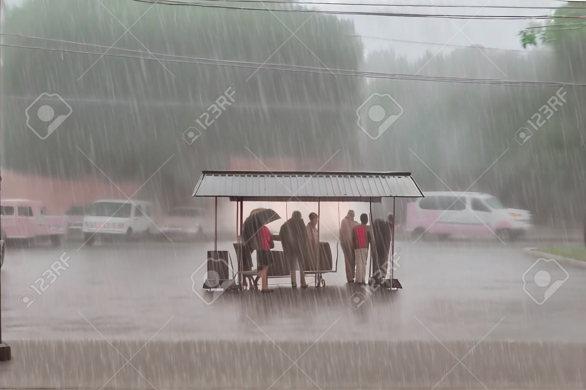 Multidão de pessoas estão se escondendo de chuva pesada em uma parada na cidade