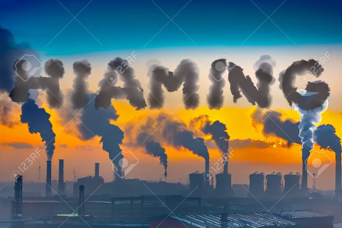 Evening view of the industrial landscape of the city with smoke emissions from chimneys at sunset- global warming