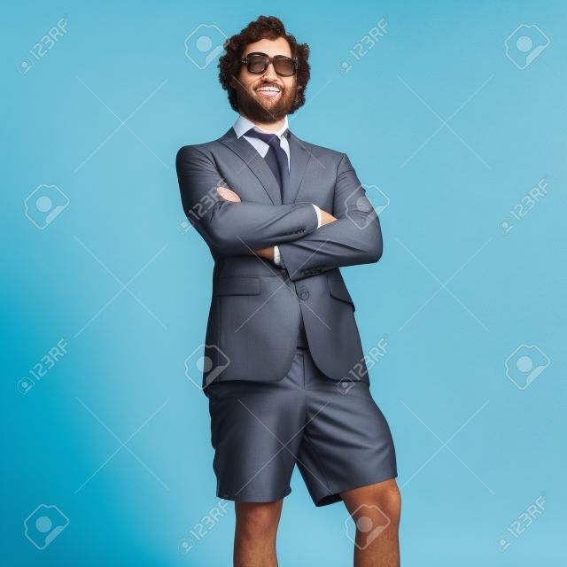 portrait of young business man wearing swimsuit against a grey background