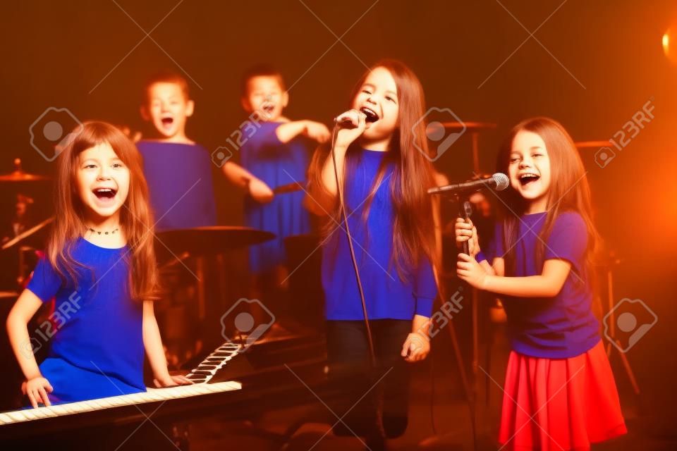 bambini felici che cantano e suonano musica