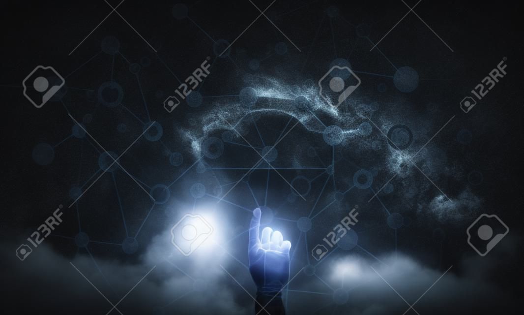 Mans hand pointing to light cloud on dark background