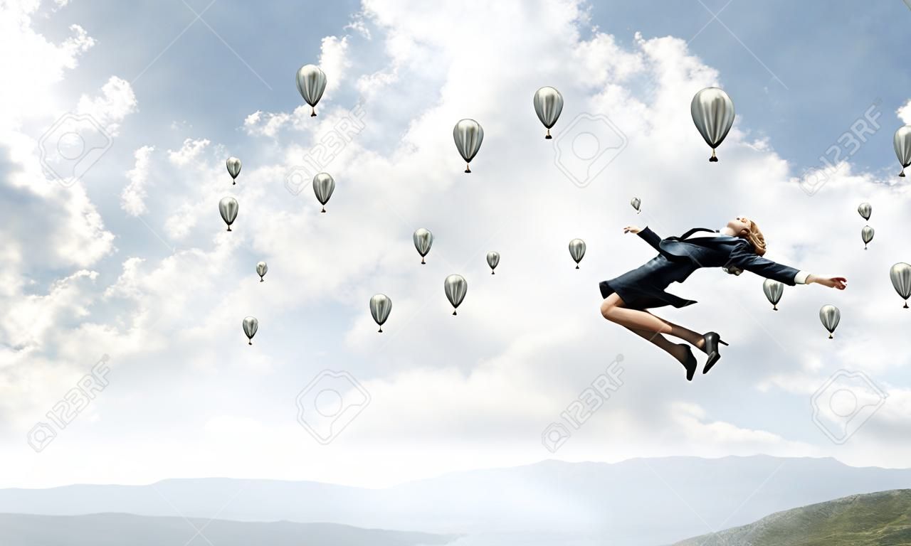 Aantrekkelijke zakenvrouw in pak springen in de lucht als symbool van actieve leven positie. Skyscape met vliegende ballonnen en natuur uitzicht op de achtergrond. 3D rendering.