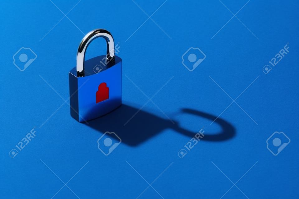 Il concetto di informazioni private disponibili, hacking. Lucchetto chiuso su sfondo blu con l'ombra di un lucchetto aperto