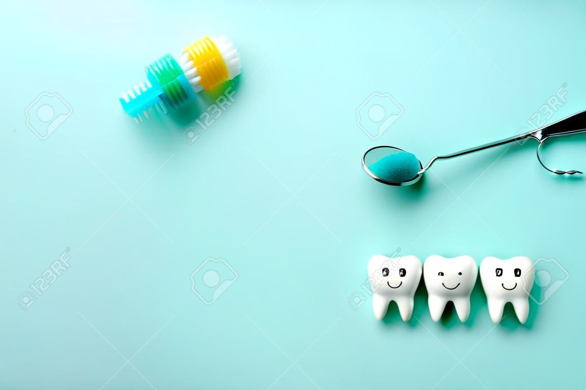 Zdrowe białe zęby uśmiechają się, a ząb z próchnicą jest smutny na zielonym miętowym tle. szczoteczka do zębów i narzędzia dentystyczne lustro, haczyk. skopiuj miejsce na tekst