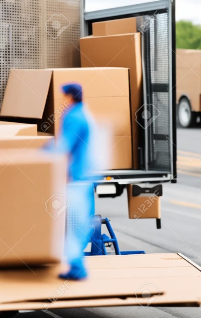 Man unloading boxes from truck by hand in the middle of a street - fast shipment goods delivery