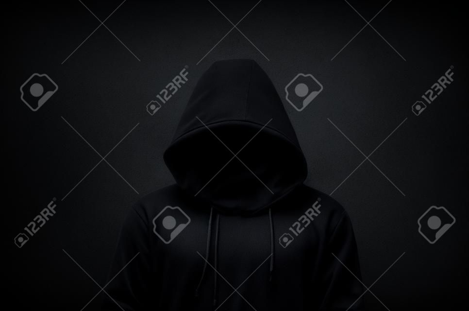 Hooded man over dark concrete background