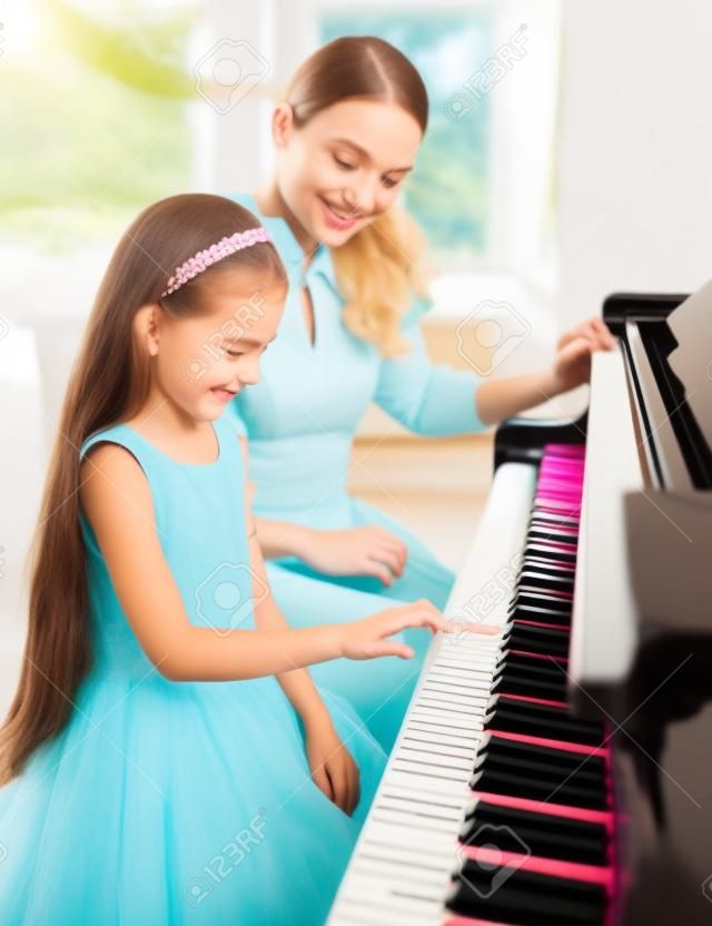 Dziewczynka uczy nauczyciel gry na pianinie. Koncepcja studiów muzyki i kreatywnego hobby