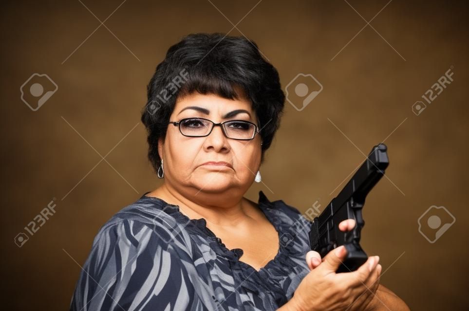 彼女は彼女の銃を持つビジネスを意味を示す 60 歳のヒスパニック系女性