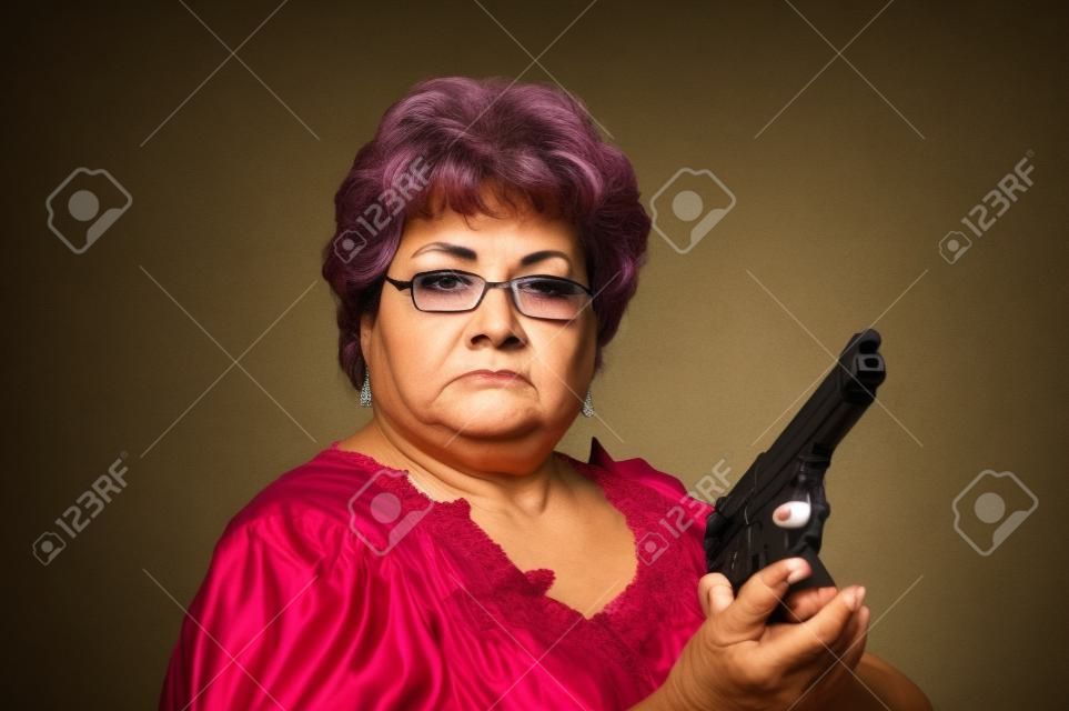 a 60 year old Hispanic woman showing she means business with her gun  