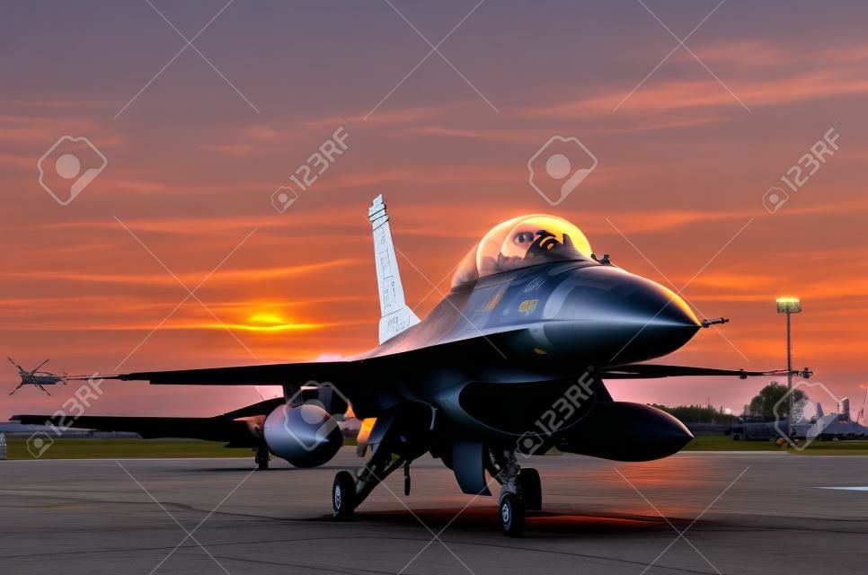 f16 falcon fighter jet parked in the airforce on sunset  background.