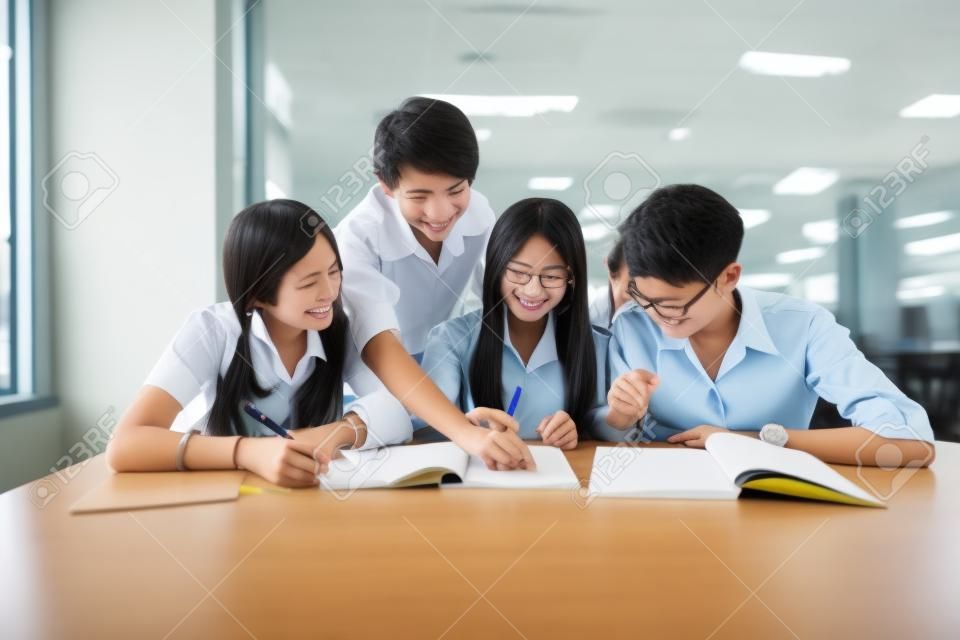 Grupo de estudiantes asiáticos en el uniforme que estudian juntos en aula