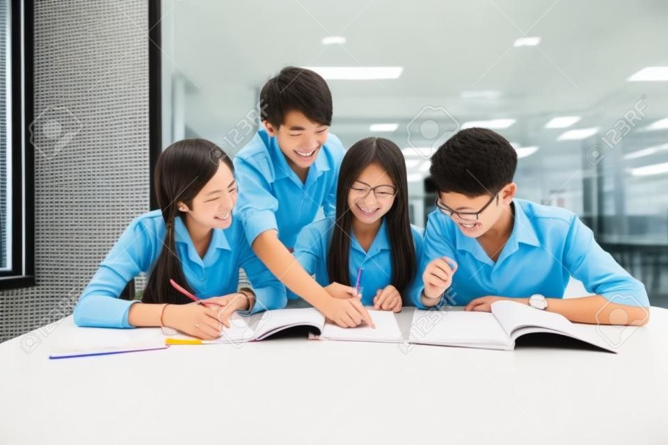 교실에서 함께 공부하는 제복을 입은 아시아 학생의 그룹