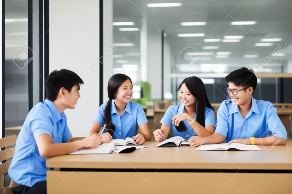 Grupo de estudantes asiáticos em uniforme estudando juntos na sala de aula