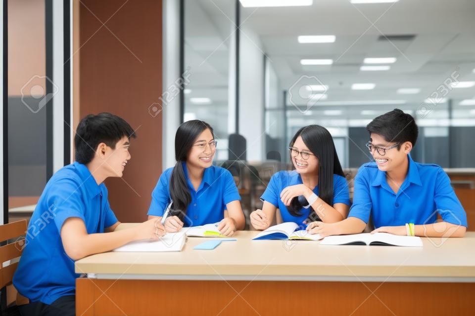 Grupo de estudantes asiáticos em uniforme estudando juntos na sala de aula