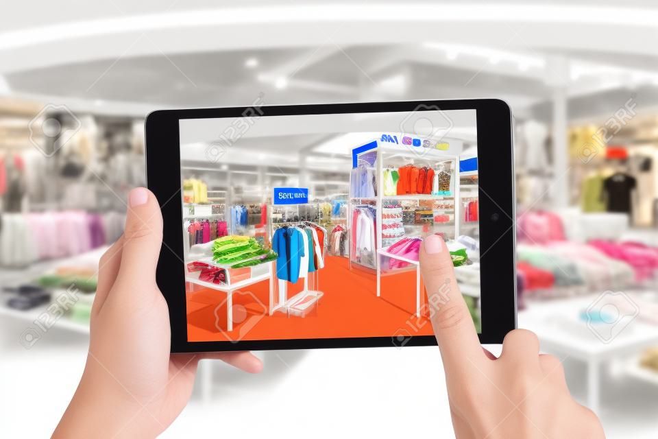Conceito de marketing de realidade aumentada. Mão segurando tablet digital smartphone usar aplicativo AR para verificar o preço de venda especial no varejo loja de moda shopping